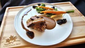 Cooks the Books: Grilled Denver Steak “Bakareta” with tomato liver sauce, California Walnut crusted rice cake and glazed California Prunes.